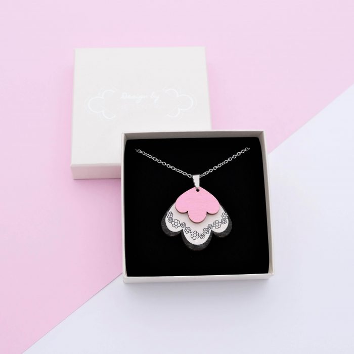 Päiväperhonen riipus, jossa kaksi osaa. Alaosa valkoinen ja yläosa pinkki. Ketjun pituus 80 cm.